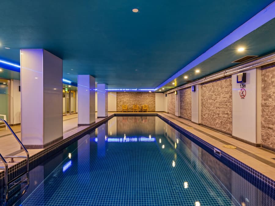 Una piscina techada, sillones reclinables de piscina