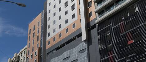 A modern high-rise building with multiple floors, large windows, and a prominent entrance area.