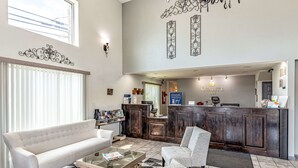 A hotel lobby with a reception desk, a sofa, a chair, and a coffee table. - Quality Inn Branson - Hwy 76 Central (Branson)