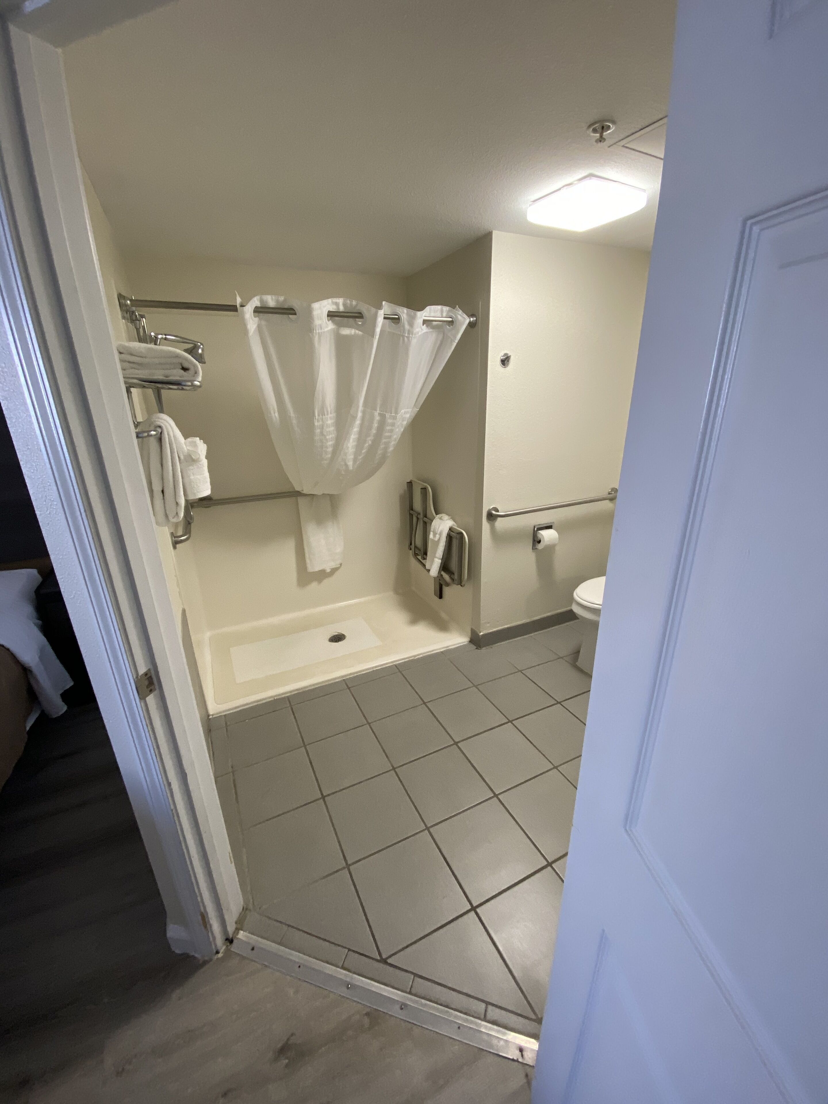Een badkamer met douche, toilet en handdoekrek.