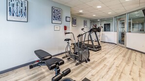 A gym with exercise equipment, including a bench, elliptical, and treadmill. - Quality Inn Branson - Hwy 76 Central (Branson)