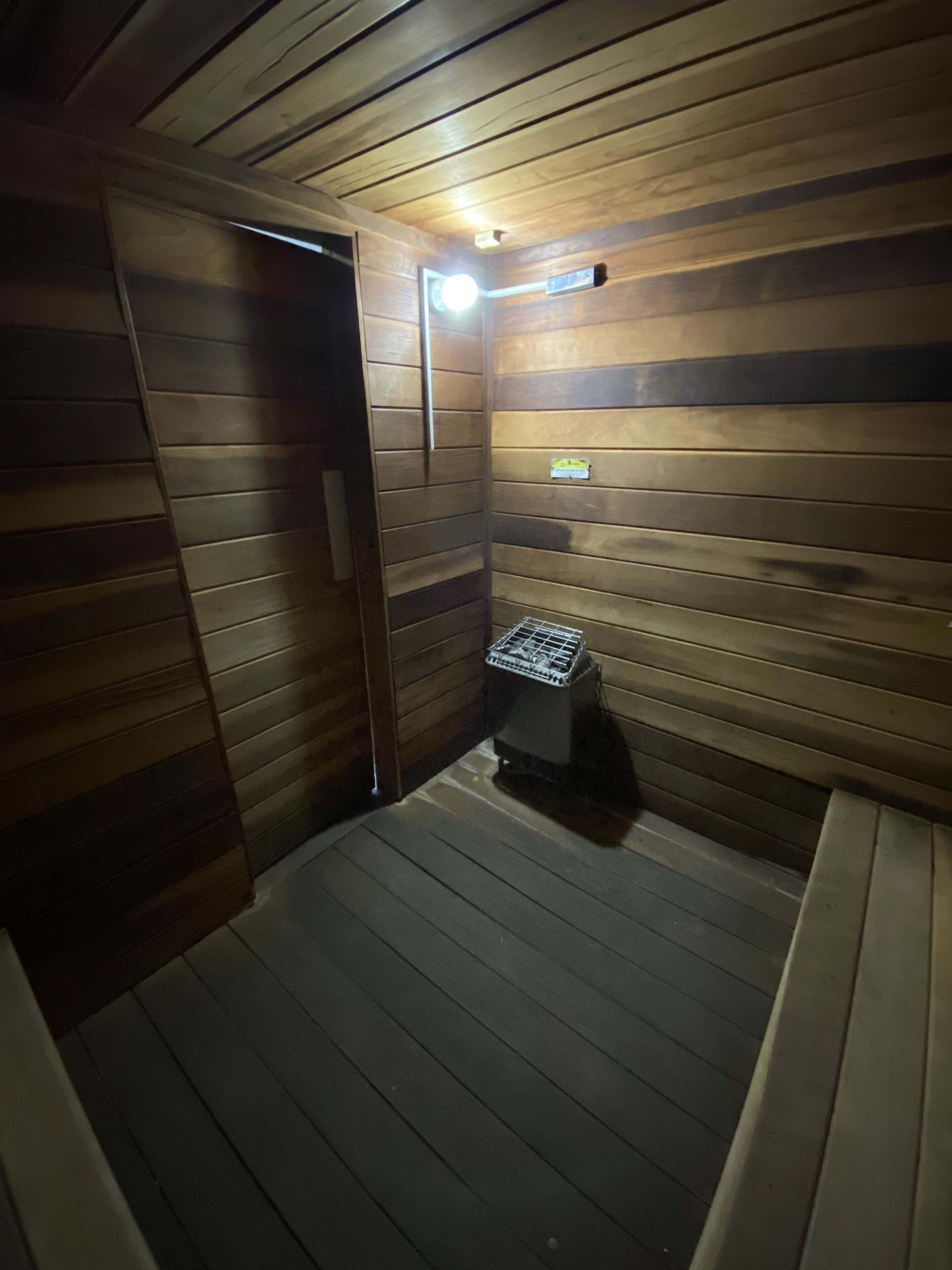 A sauna room with wooden walls and a bench.