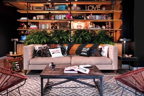 Relax in this inviting living room with a sofa, bookshelf, and potted plant.