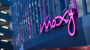 A building with a neon sign that reads "Woxy".