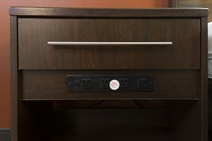 Un cassetto di legno con maniglia metallica e una ciabatta con presa.
