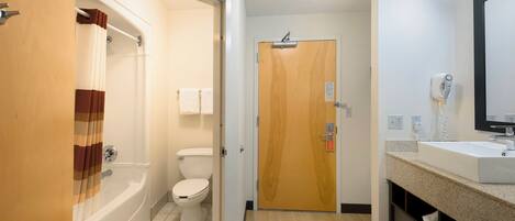 A bathroom with a bathtub, toilet, and sink.