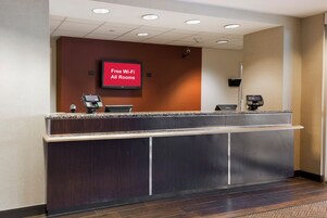 A hotel reception desk with a digital display advertising free Wi-Fi in all rooms.