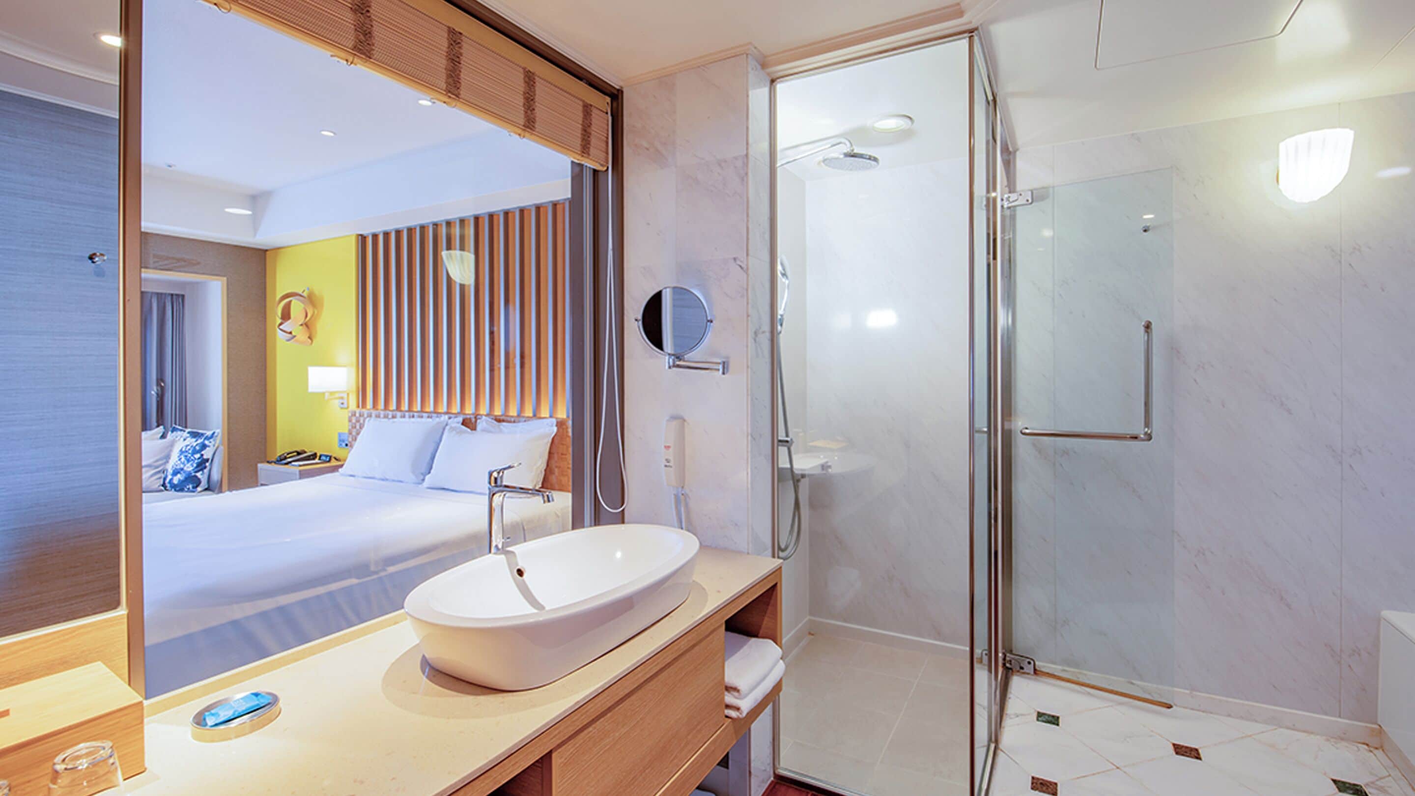 A modern bathroom with a large mirror, a sink, and a shower.