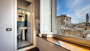 A bathroom with a window view of a historic town, a sink, and a mirror. - Hotel De Lanzi (Florence)