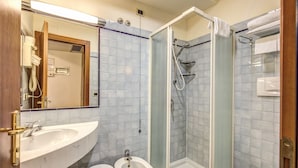 Un baño con lavamanos, bidé y ducha.
