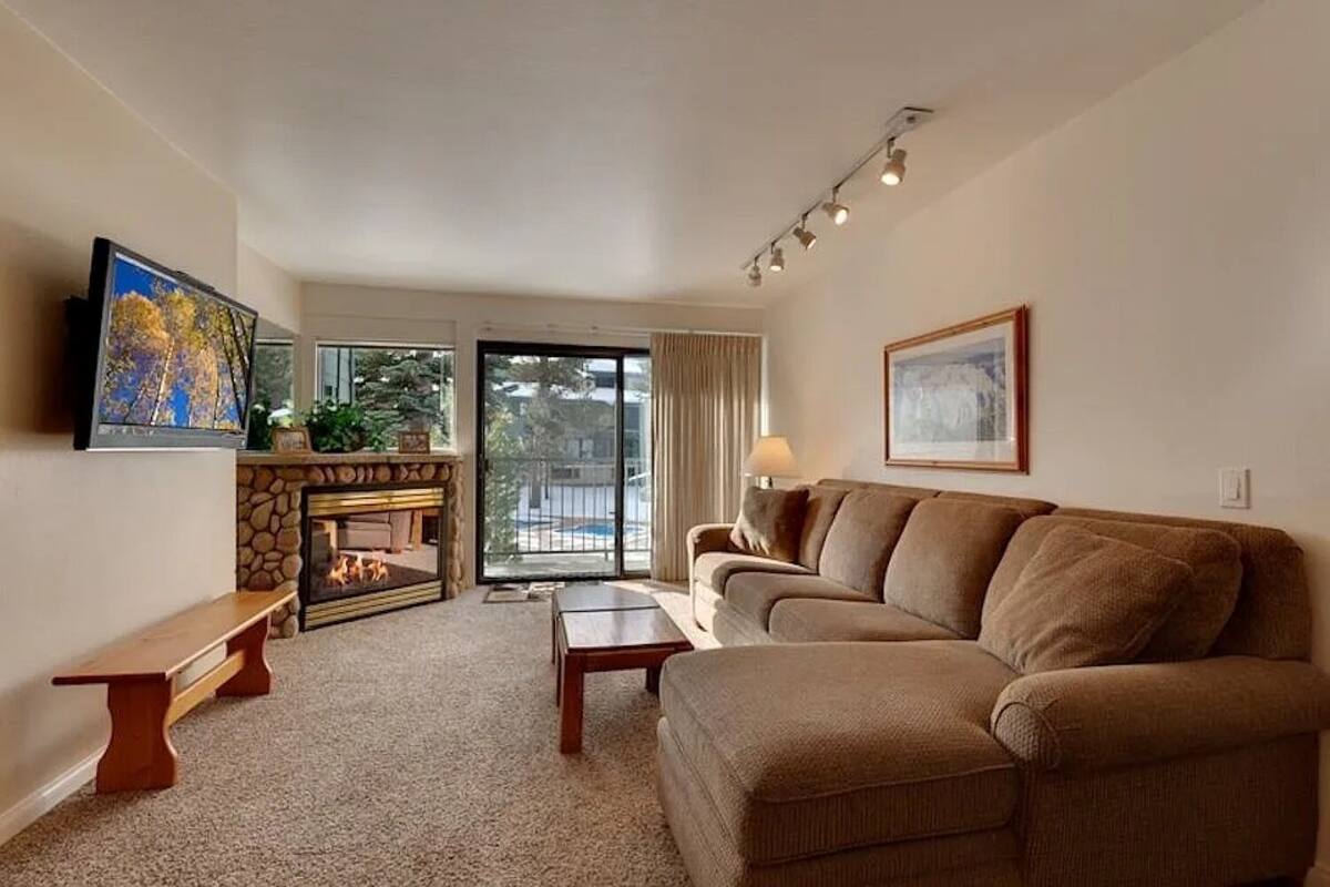 A living room with a fireplace, a sofa, a coffee table, and a TV.