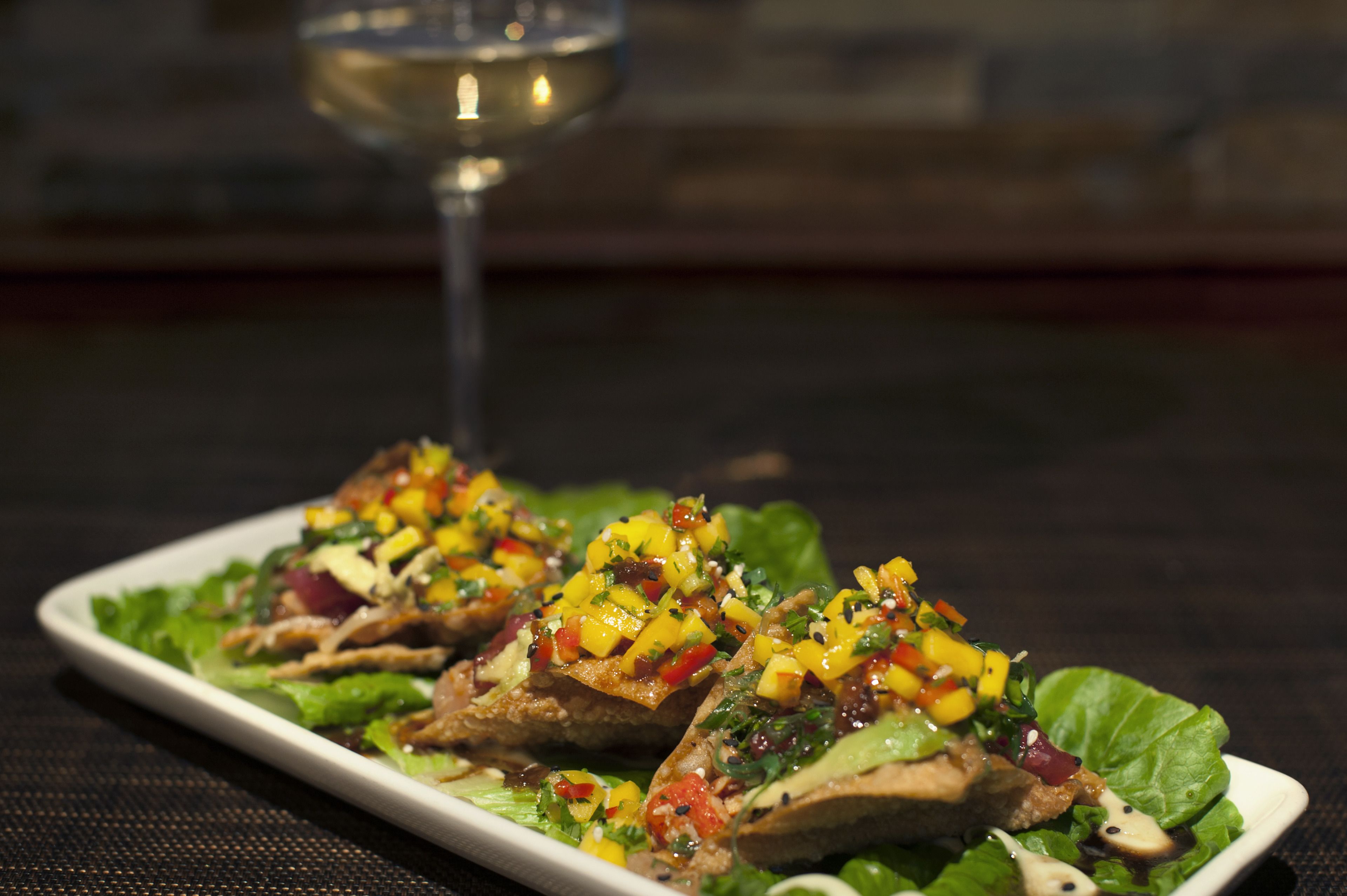 A plate of food with a glass of white wine.