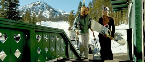 A green bridge with heart-shaped cutouts, a sign for a restaurant lounge, and a snowy mountain in the background.