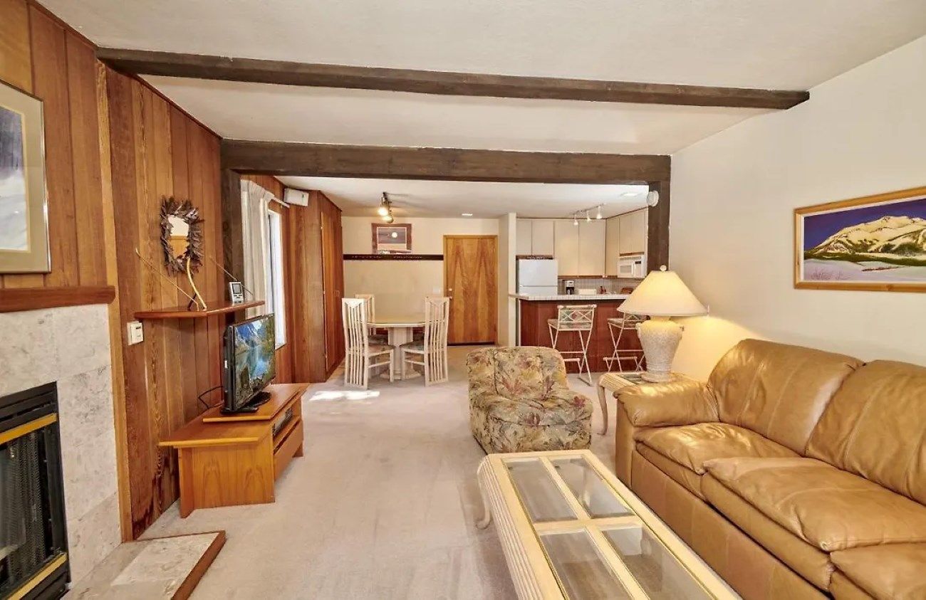 A living room with a fireplace, a sofa, a coffee table, and a television.