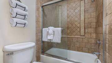 Un bagno con cabina doccia in vetro, un water bianco e una vasca.