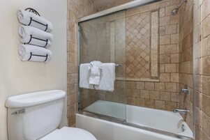 Un bagno con cabina doccia in vetro, un water bianco e una vasca.