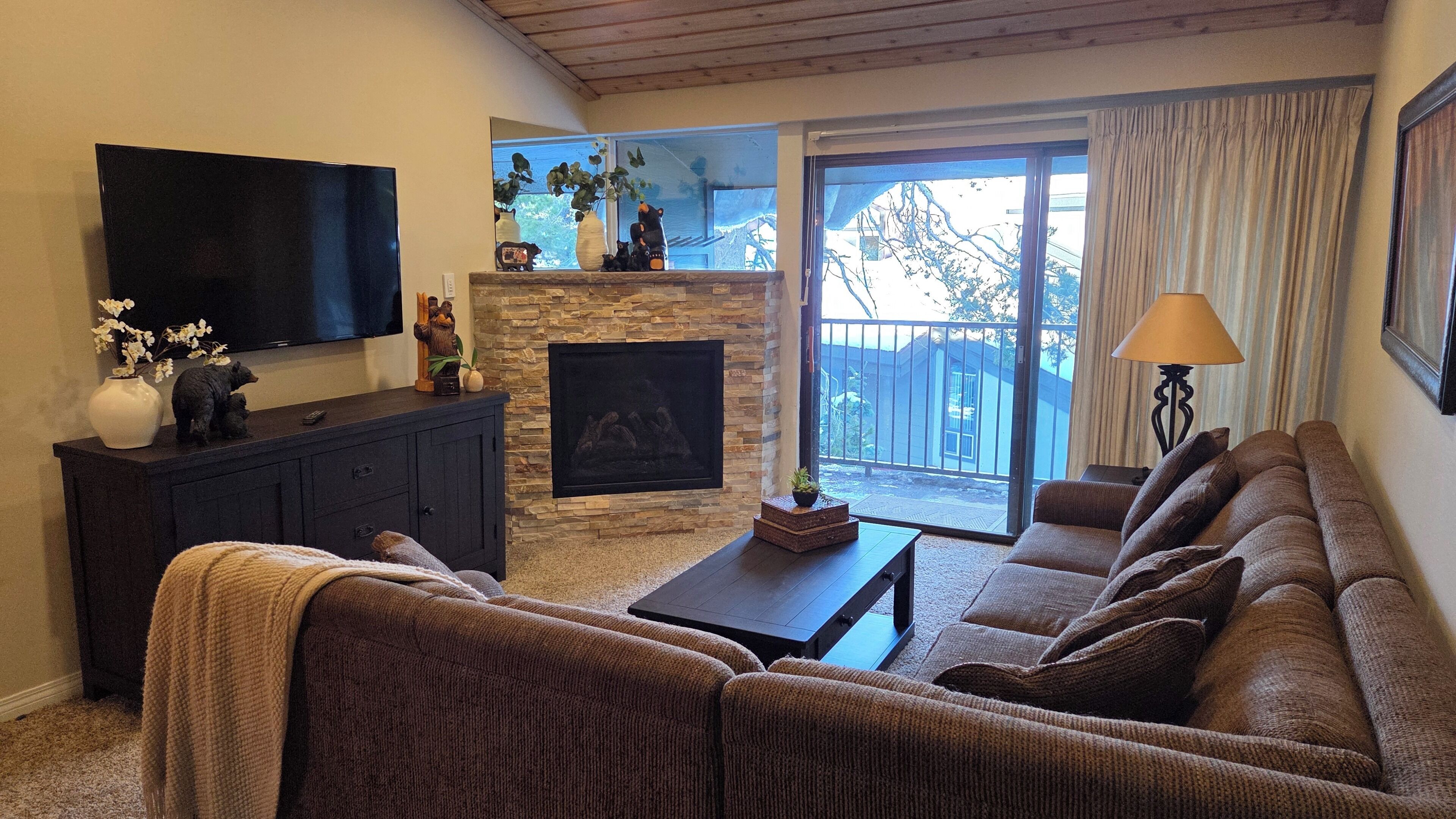 Una sala de estar con chimenea, televisión y sofá.