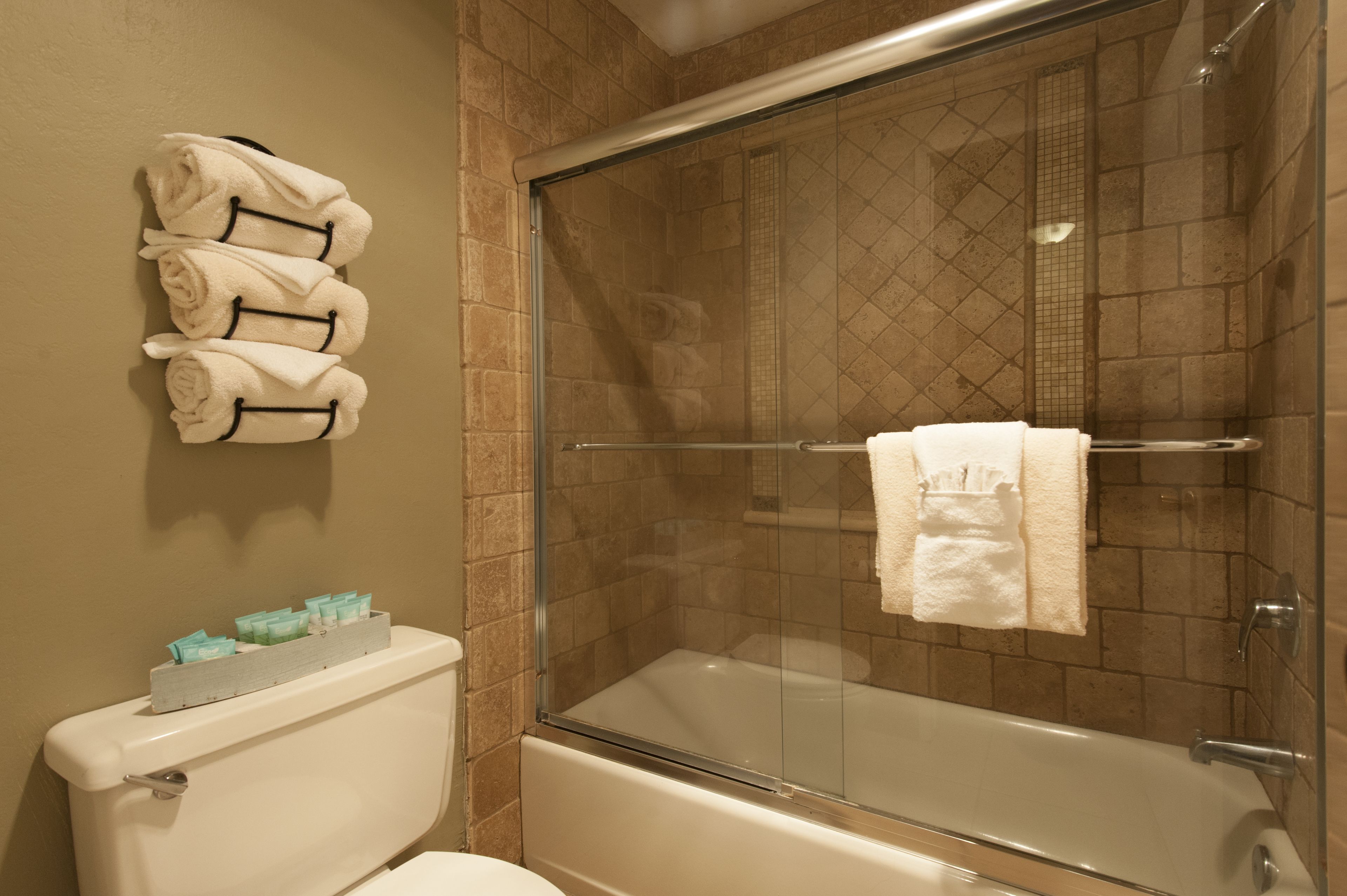A bathroom with a glass-enclosed shower, a toilet, and a bathtub.