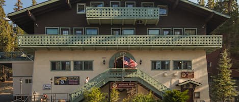 A building with a sign reading "Austria Hof" and an American flag. There are stairs leading to a balcony with a railing.