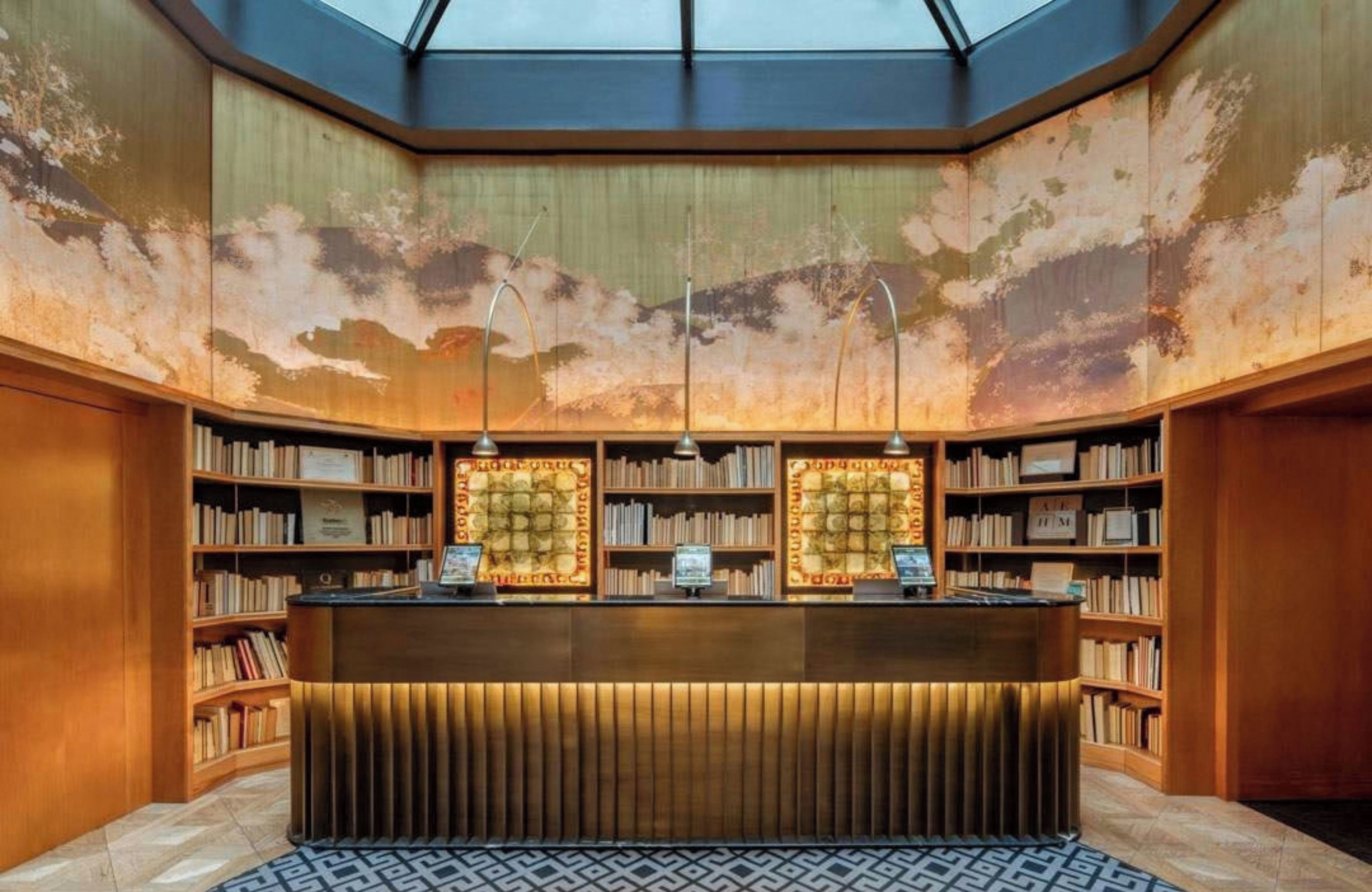 A library with a skylight, bookshelves, and a reception desk.