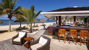A beachside bar with wicker furniture, a bar counter, and a view of the ocean. - Sandals Negril - ALL INCLUSIVE Adults Only (Negril)