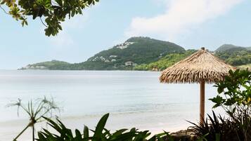 On the beach, white sand, sun loungers, beach umbrellas