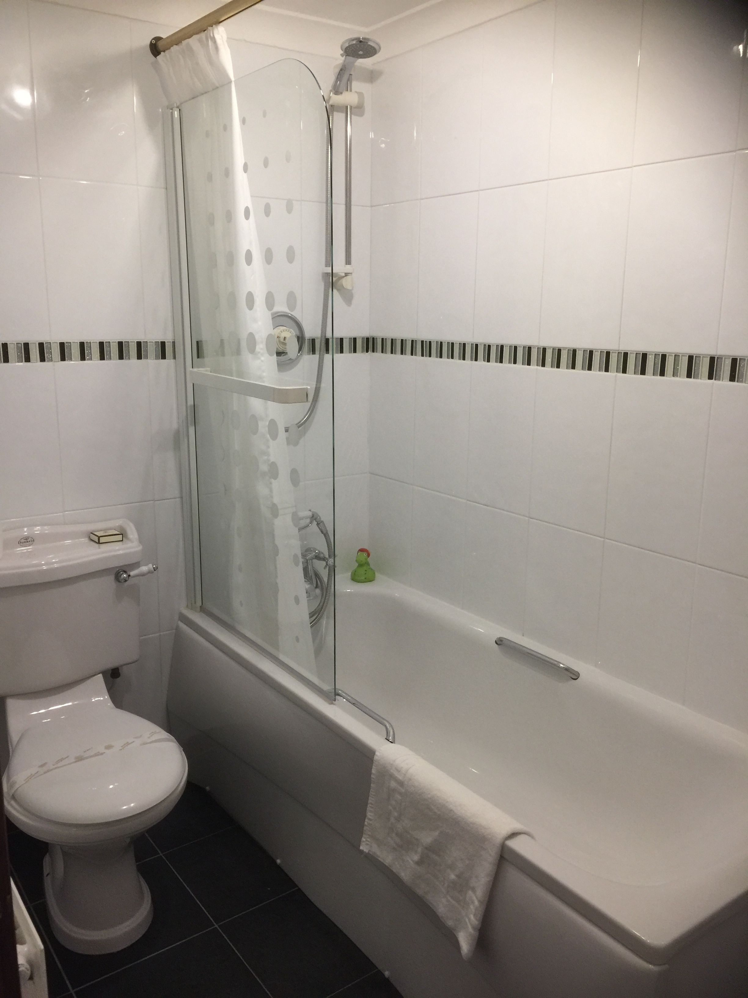 Une salle de bain avec une douche à parois de verre, des toilettes et une baignoire.