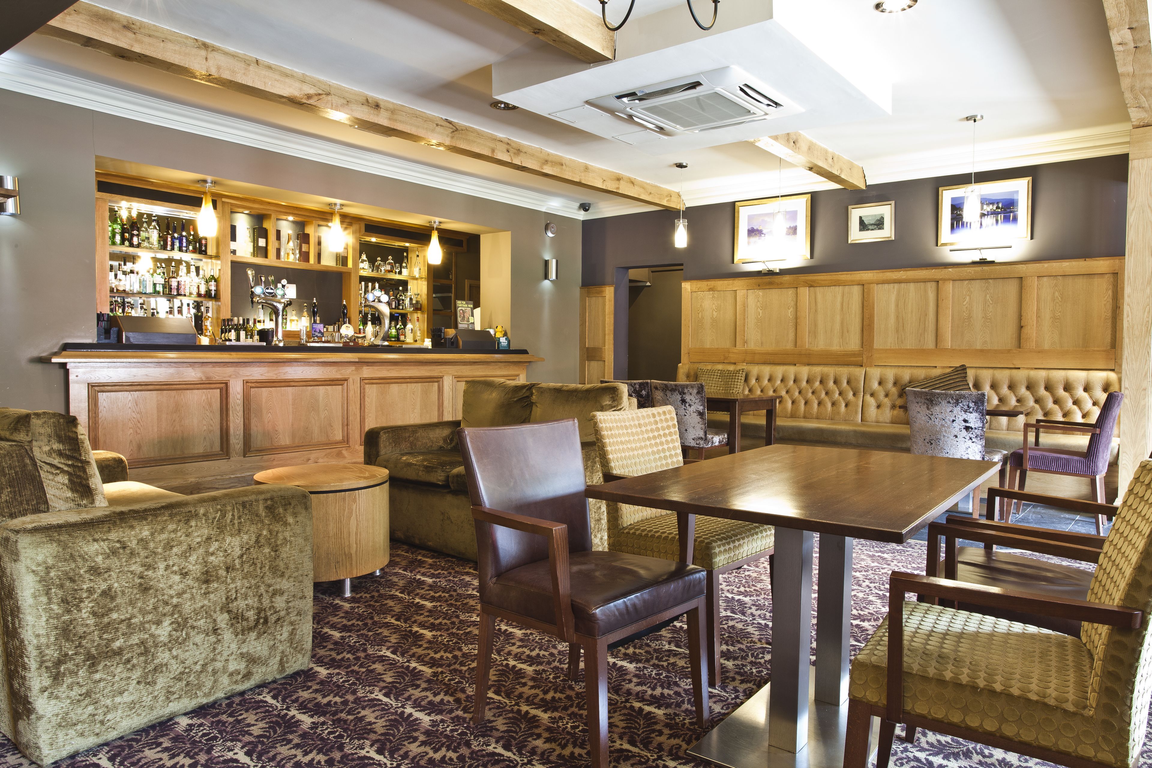 Eine Bar mit Holzsitzmöbeln und einer Theke, bestückt mit Flaschen.