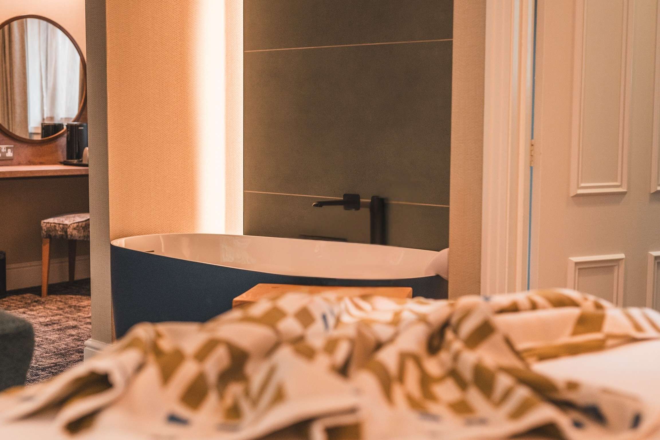 A bathroom with a bathtub, a sink, and a mirror.