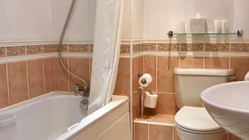 A bathroom with a bathtub, toilet, and sink.