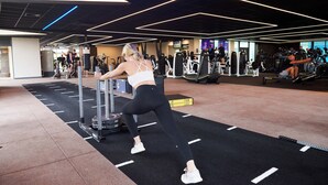 A gym with exercise equipment, a black rubber floor, and a high ceiling with geometric lighting. - The Wrightington Hotel & Health Club (Wigan)