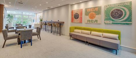 A modern waiting area with a sofa, chairs, and tables.