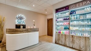 A spa reception area with a wooden reception desk, a neon sign, and a wall of spa products. - The Wrightington Hotel & Health Club (Wigan)