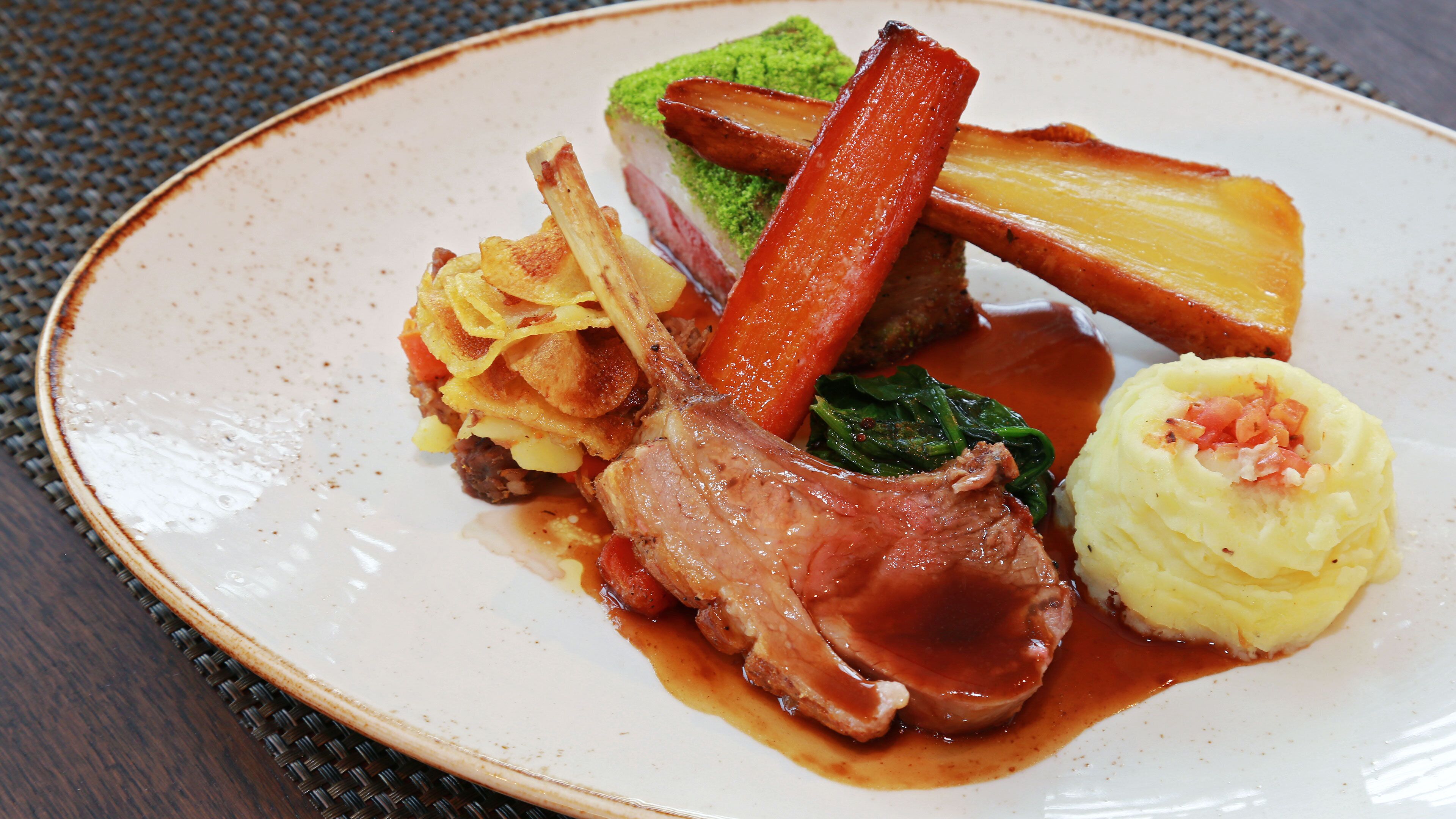 A plate of food with various items including meat, vegetables, and mashed potatoes.