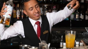 A bartender pouring a drink into a glass. - Donnington Manor Hotel (Sevenoaks)