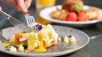 A plate of food with a fork, including poached eggs, smoked salmon, and hollandaise sauce.