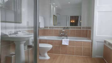 Un baño con lavamanos pedestal, bañera y retrete.