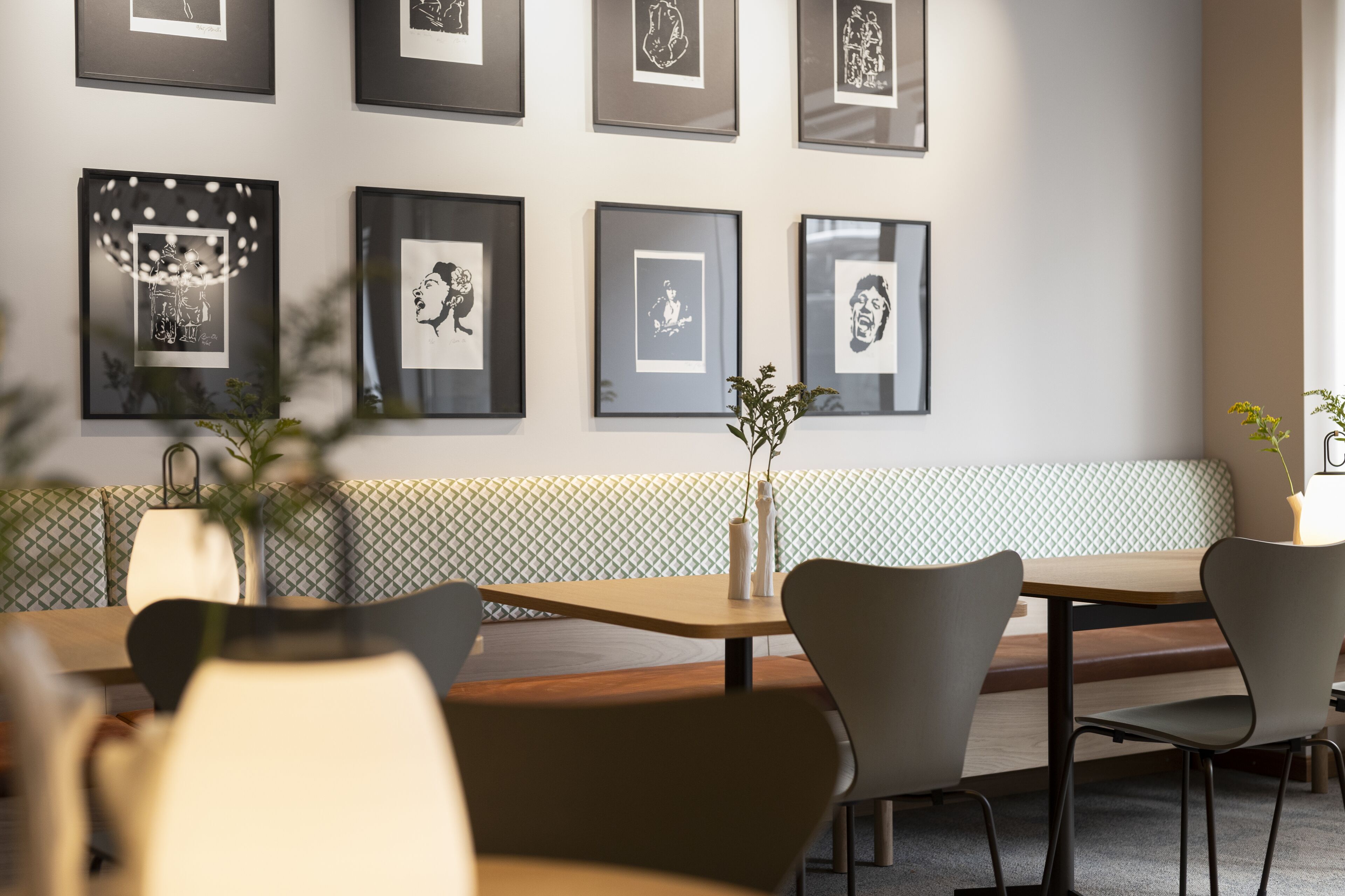 Un comedor moderno con un banco estampado, una obra de arte enmarcada en la pared y muebles minimalistas.