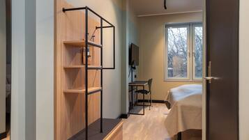 Un dormitorio con cama, escritorio y estantería de madera empotrada.