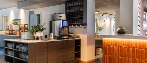 Cozinha moderna com ilha central, prateleiras embutidas e máquina de café.
