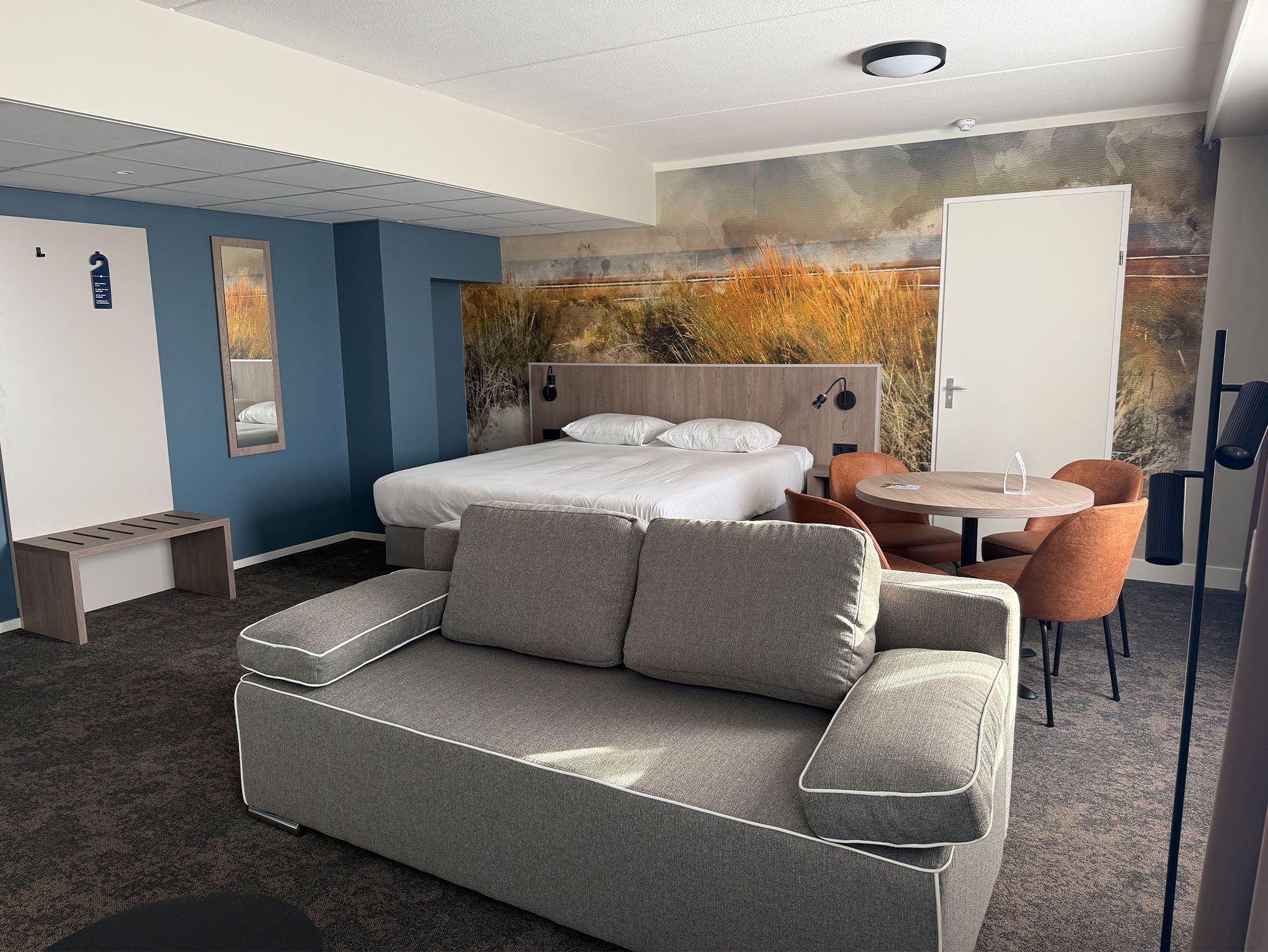 Une chambre d’hôtel moderne équipée d’un lit, d’un canapé, d’une table à manger et d’une chaise.