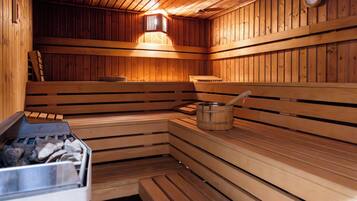 Een sauna met houten banken en een emmer.