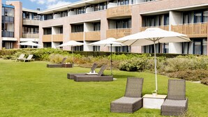 Een hotel binnenplaats met buitenmeubilair en een gebouw met balkons.