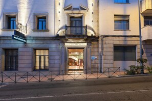 A hotel entrance with a balcony, a sign reading 'Alfonso VIII', and a gated entrance. - Dorma Alfonso VIII (Plasencia)