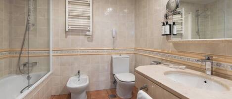A bathroom with a bathtub, a shower, a bidet, a toilet, and a sink with a mirror.