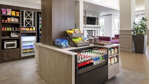 Un hall d’hôtel doté d’un bar à collations en libre-service, d’un four à micro-ondes et d’un réfrigérateur.
