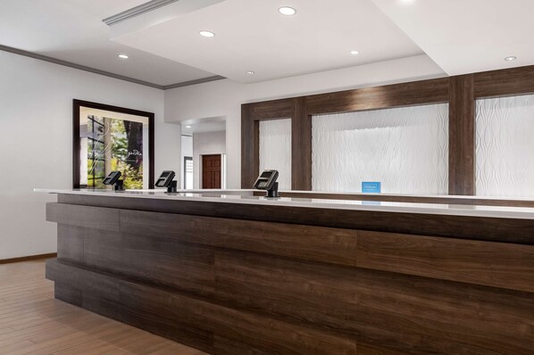 Welcome to our reception area, featuring a stylish desk with a framed artwork above and a comfortable atmosphere.