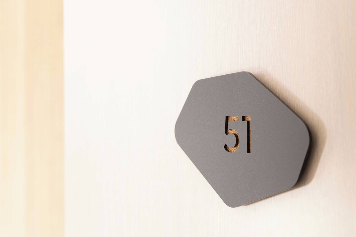 A hexagonal, grey wall-mounted number plate with the number 51.