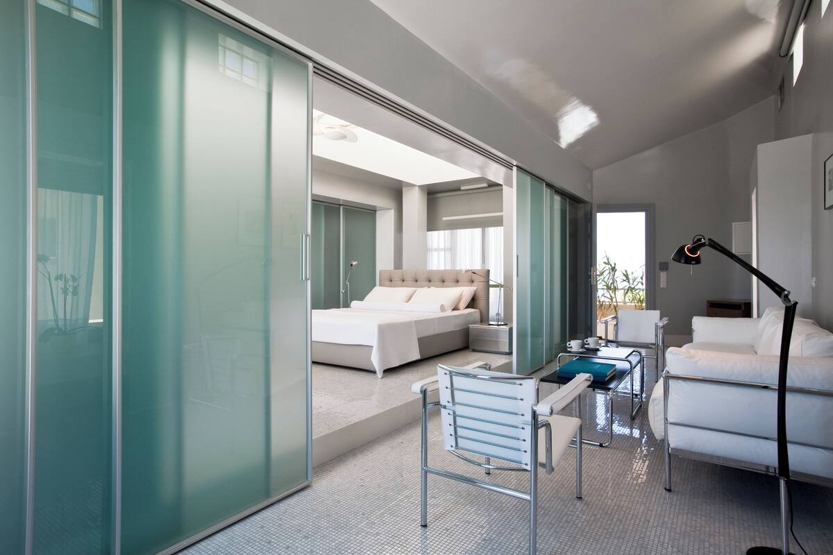 Une chambre d’hôtel moderne, équipée d’un lit, d’un bureau, d’une chaise et d’un canapé.