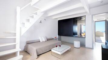 A modern living room with a staircase, a sofa, a coffee table, and a view of the outdoors.